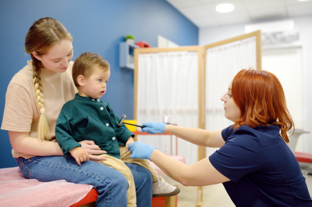 Baby and his mother are being seen by a pediatric neurologist in a modern medical clinic